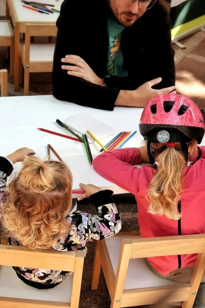 Schulbegleiter sitzt neben Kind am Tisch – Integrationshilfe Krefeld